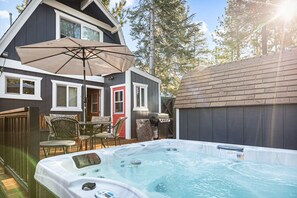 Outdoor fully equipped with a hot tub, seating area, and a barbecue.