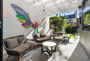 Relax and dine alfresco in this vibrant outdoor space, complete with a colourful mural backdrop, comfortable seating and direct access to the private pool.
