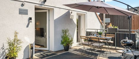 Große Dachterrasse mit Gartenmöbeln, Sonnenschirm und Grill