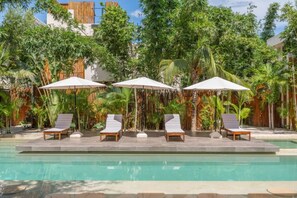 Relax poolside in a sunny shared space with seating