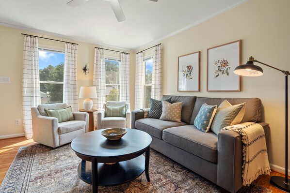 The living room is spacious and filled with natural light. 