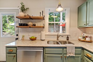 View of the kitchen from the nook. Open shelves keep things within easy reach. 