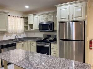 Kitchen with hud microwave, dishwasher, full stove, refrigerator, island and lots of storage