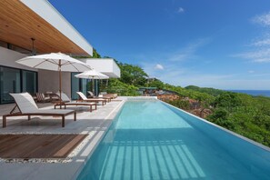 Amazing, oversized, infinity edge pool, with a shallow lounge area at the oposite end of this photo