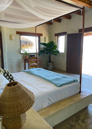 Master Bedroom with deck overlooking the beach and wave. 