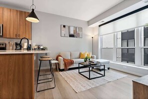 A bright, modern retreat with a sleek kitchen, cozy seating, and large sunny windows.