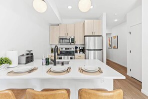 Bright, modern kitchen with stainless steel appliances, island seating, and style