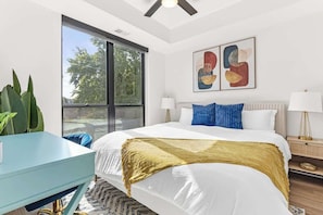 Relax in a serene bedroom with a plush king bed, natural light, and modern touches.