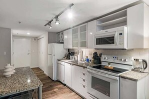 Fully equipped modern kitchen with granite countertops, sleek appliances, and style.