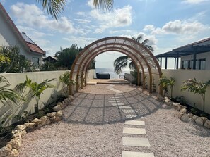 Arch over garden leading to patio, stairs and jacuzzi
