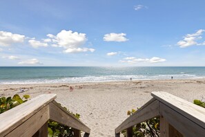 Peaceful beach view with wooden walkway leading to the shore.