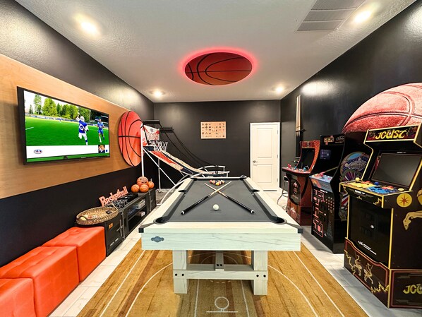 Game room with pool table and arcade games for endless fun.