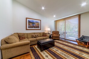 Bright living room with windows overlooking teh beautiful mountain scenery. Comfortable section sofa with sleeper sofa.