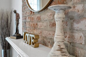Elegant touch of 'LOVE' — this cozy mantel features soft florals and rustic exposed brick, reflecting the heart of New Orleans' charm.