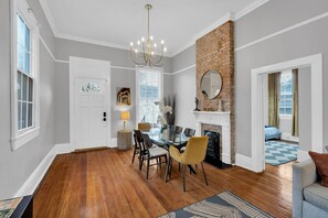 Gather in style! This beautifully designed open-plan dining and living area features exposed brick, modern furnishings, and plenty of natural light—perfect for hosting memorable meals and cozy nights in.