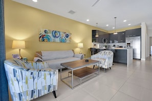 This cozy, open-concept living area features stylish seating with a sofa and two accent chairs, perfect for relaxation.