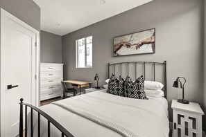 Bedroom 1 with queen bed, clothing storage and dedicated workspace 
