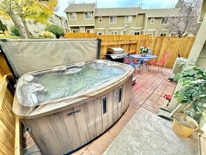 Discover a serene retreat featuring a lavish hot tub, a comfortable sitting area, and a grilling space in this beautifully designed backyard. Ideal for unwinding, stargazing, and creating cherished memories with friends or enjoying a quiet getaway.