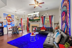 Spacious and eclectic living room with a cozy fireplace and plenty of seating. Perfect for entertaining guests or relaxing with family.
