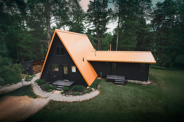 the front of the a-frame features a spacious yard and ultimate privacy.