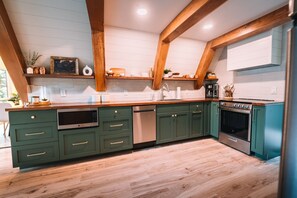 the fully stocked kitchen features a refrigerator, microwave, dishwasher, electric range and many other amenities.