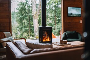 the living room features a jotul gas fireplace, leather couch, and a large picture window with views of finch creek.