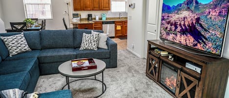 Living room with 65 inch smart TV with electric fireplace and XBOX/DVD player.