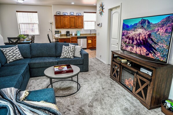 Living room with 65 inch smart TV with electric fireplace and XBOX/DVD player.