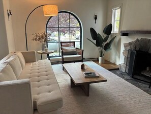 Sun filled living room with wood burning fireplace.