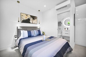 Elegant studio bedroom with en-suite bathroom, modern decor, and cozy ambiance.