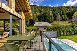 Balcony with dining furniture overlooking large hot tub