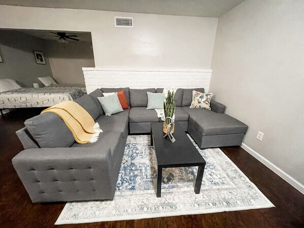 Cozy living room with a sectional converted to a sofa bed and extra beds for added comfort.