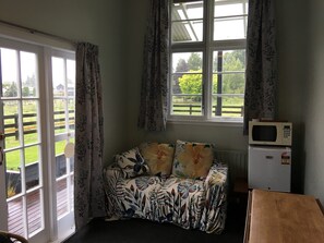 Small living room with fridge, microwave and fold out dining table.