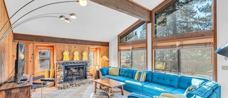 Living Room: Large sectional couch, chair, 65” Smart TV, wood-burning fireplace