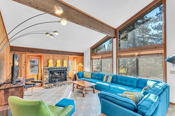 Living Room: Large sectional couch, chair, 65” Smart TV, wood-burning fireplace  
