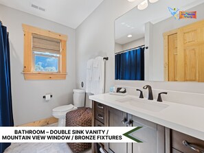 Spacious bathroom with double vanity, modern fixtures, and natural light.