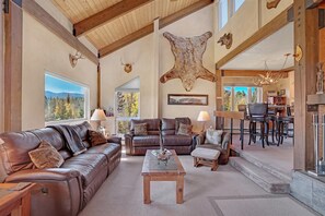 Cozy up in the large living room with wood burning fireplace, amazing mountain views, and large smart TV for an ideal apres ski