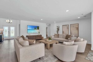 The family room includes 2 sofas and 2 swivel chairs along with a large coffee table and a wall mounted TV 