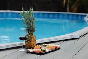 Immerse yourself in the pleasure of an afternoon in this beautiful park by the pool, surrounded by nature, a cheese board, fresh fruits, and the special touch of a glass of wine.