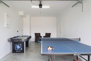 A spacious game room in the garage has a ping pong table and games area to keep everyone entertained.
