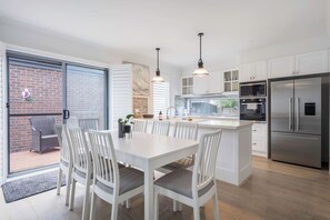 The open-plan dining area offers a welcoming space to gather, perfect for enjoying meals. With natural light flowing in, it’s an inviting spot for relaxed dining or lively conversation.