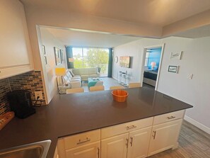 open concept view from kitchen to living room & balcony