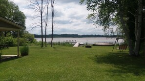 View of front lawn, dock, and lake 