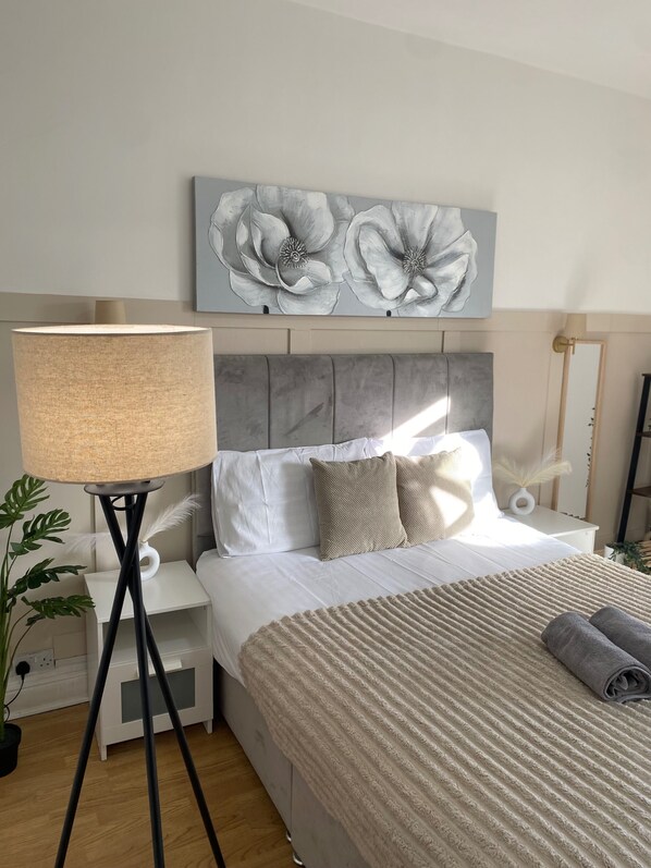 Bright and open bedroom with plenty of space and a neutral toned theme 
