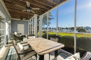 Sip coffee in the screened in porch with marina views! Perfect for breakfast or lazy afternoons.