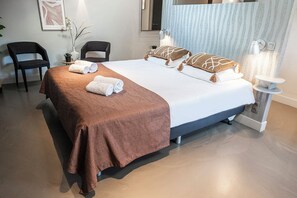 Inviting and elegant, this bedroom features a large, comfortable bed with stylish brown bedding and decorative pillows, creating a cozy retreat for relaxation. The soft lighting and minimalist decor enhance the serene atmosphere.