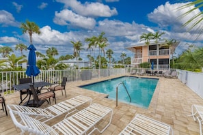 Shared Heated Pool has Sun Loungers and Dining Tables with Umbrellas