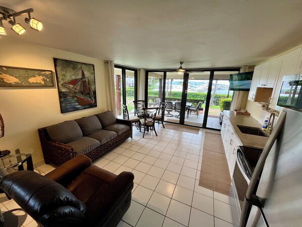Living room with double sofa sleeper, fully stocked kitchen, and dining area.