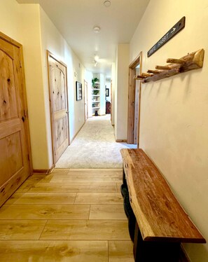 Entry way with space for jackets, shoes, and a closet with a ski rack and sleds