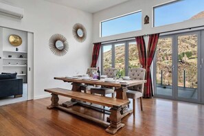 The huge dining table is truly fit for a King and his family... or a Queen and hers.

Enjoy fantastic views over the mountains and the Shotover River from the massive dining room and kitchen.  

The concertina doors open up wide out onto the patio.